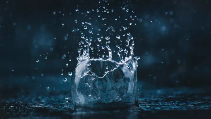 Salpicadura de agua en corona sobre una superficie oscura