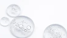 Gotas de sérum de niacinamida sobre superficie de cristal transparente