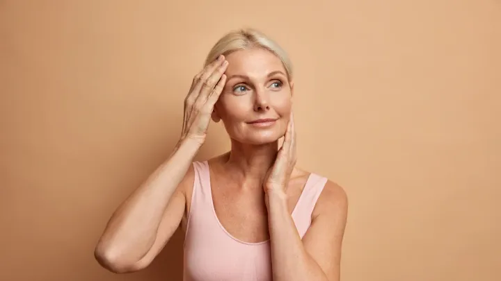 Productos de skincare para rutina de piel madura sobre fondo neutro